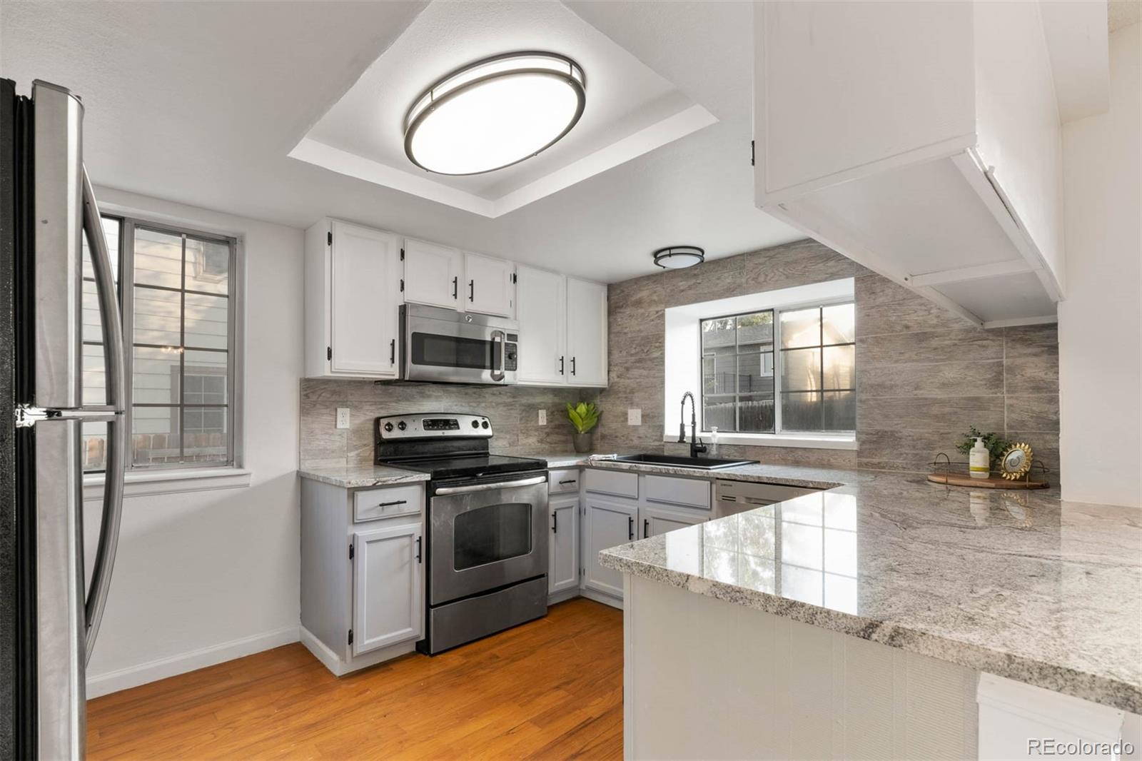 6283 Xavier Street Arvada, CO 80003 - Photo 8 of 36 a kitchen with stainless steel appliances granite countertop a stove a sink and a microwave