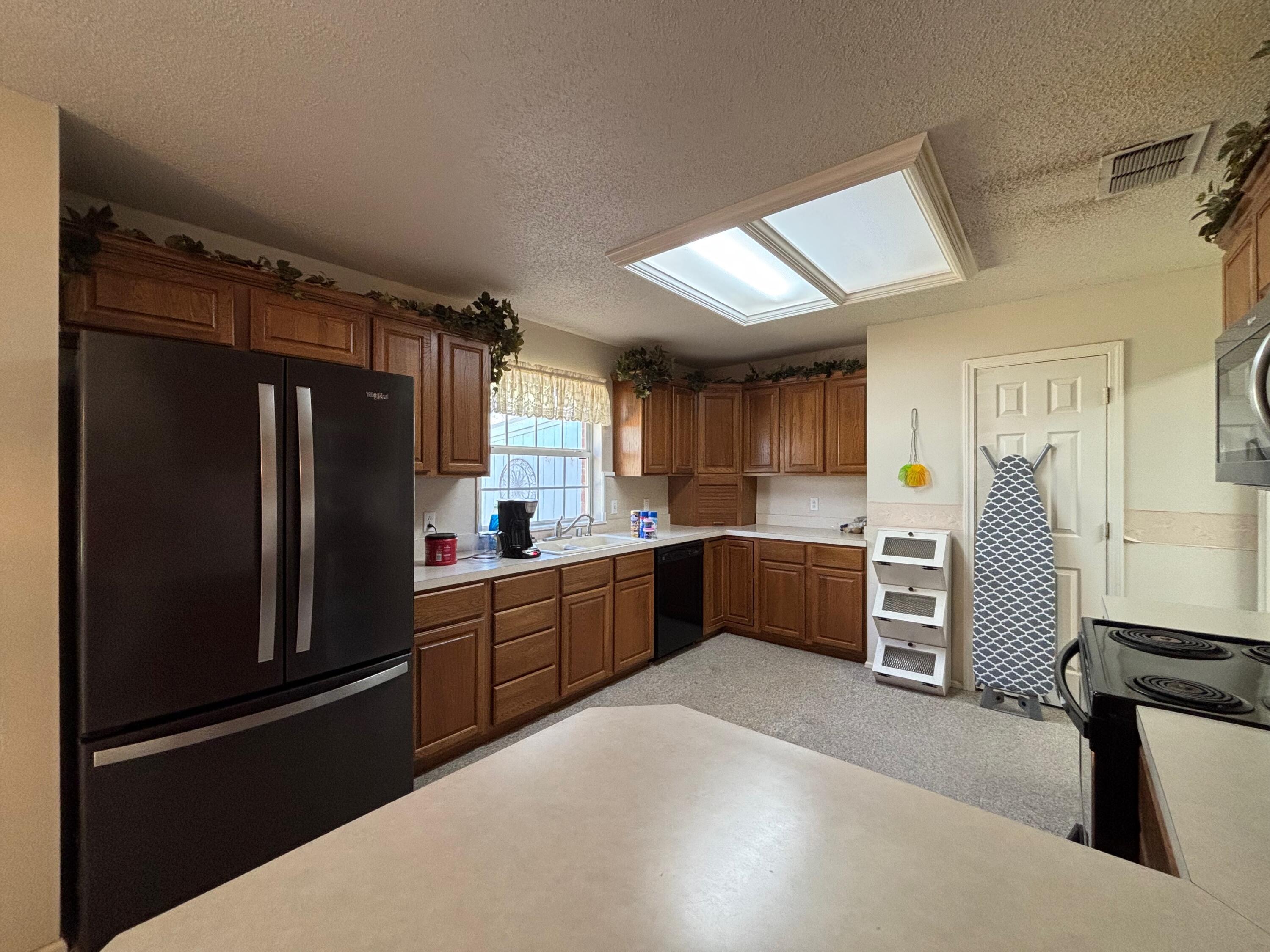 1502 Culpepper Avenue Wilson, TX 79381 - Photo 15 of 26 a kitchen with stainless steel appliances kitchen island granite countertop a refrigerator and cabinets