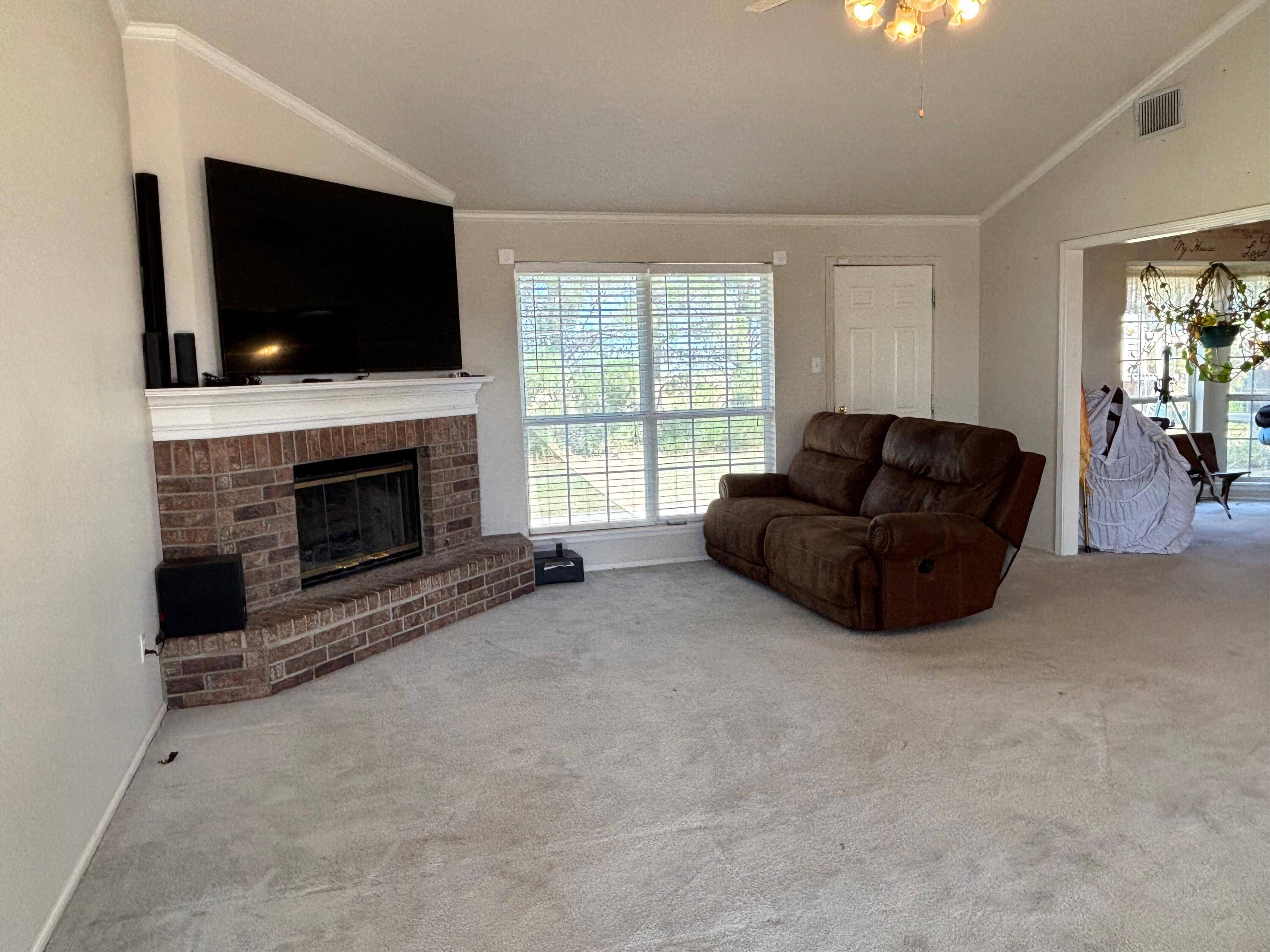 1502 Culpepper Avenue Wilson, TX 79381 - Photo 4 of 26 a living room with furniture a flat screen tv and a fireplace