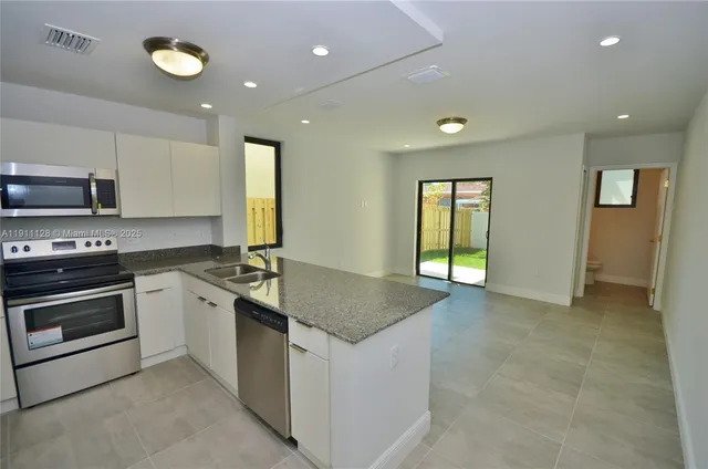 a kitchen with stainless steel appliances granite countertop a stove and a sink