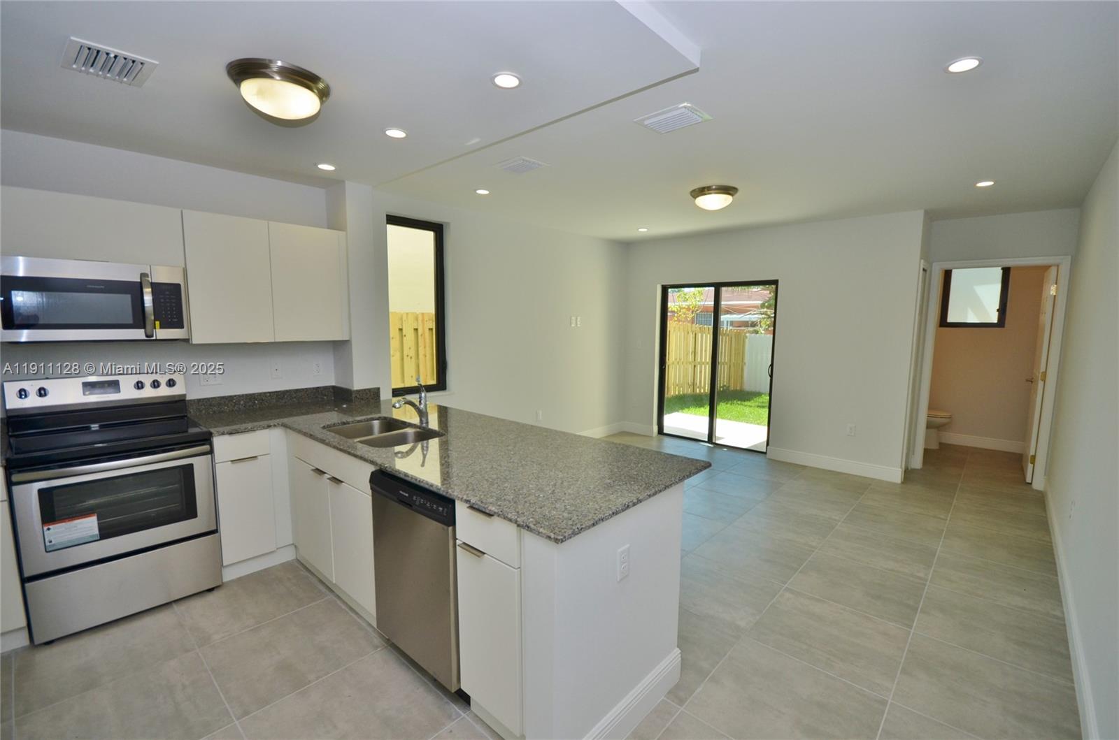 4374 East 10th Avenue, Unit 4374 Hialeah, FL 33013 - Photo 11 of 29 a kitchen with stainless steel appliances granite countertop a stove and a sink