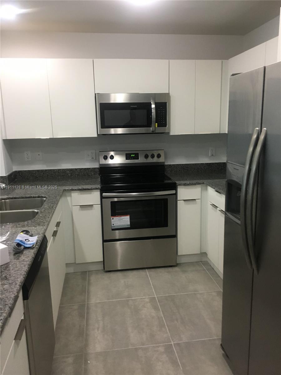 4374 East 10th Avenue, Unit 4374 Hialeah, FL 33013 - Photo 12 of 29 a kitchen with a stove microwave and refrigerator