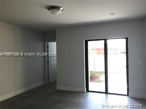 4374 East 10th Avenue, Unit 4374 Hialeah, FL 33013 - Photo 16 of 29 an empty room with wooden floor and windows
