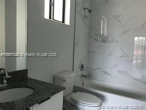 4374 East 10th Avenue, Unit 4374 Hialeah, FL 33013 - Photo 21 of 29 a bathroom with a granite countertop toilet sink and mirror