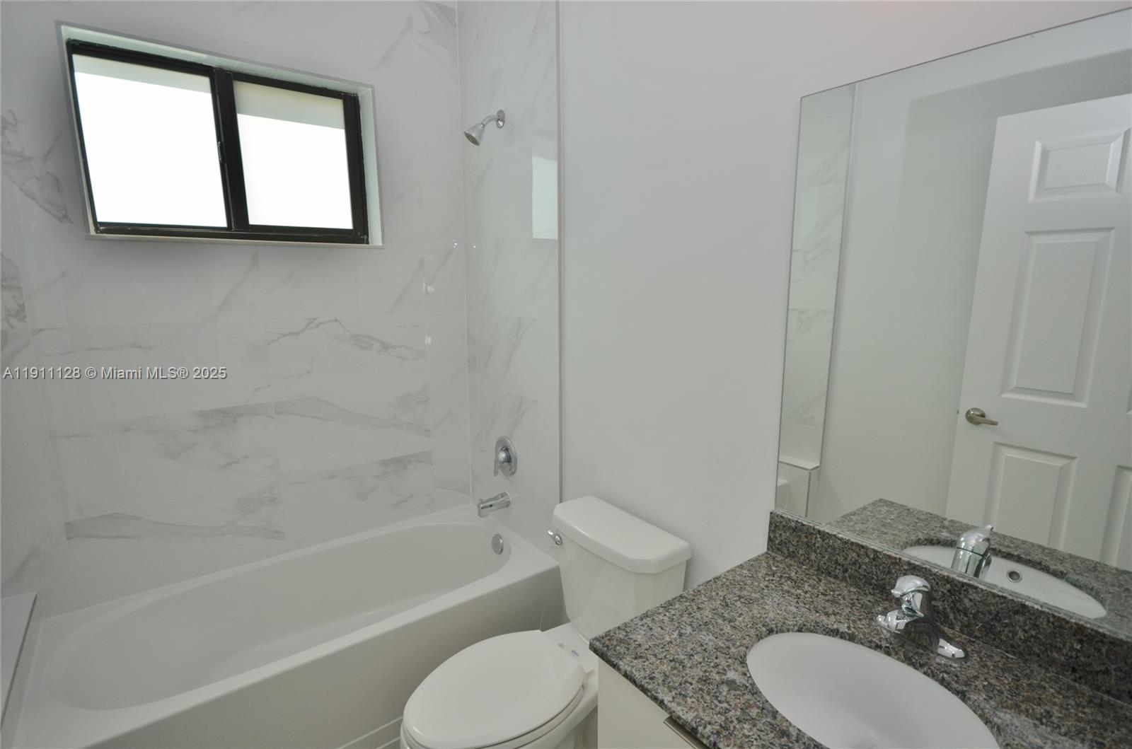 4374 East 10th Avenue, Unit 4374 Hialeah, FL 33013 - Photo 23 of 29 a bathroom with a granite countertop sink toilet a mirror and a bathtub