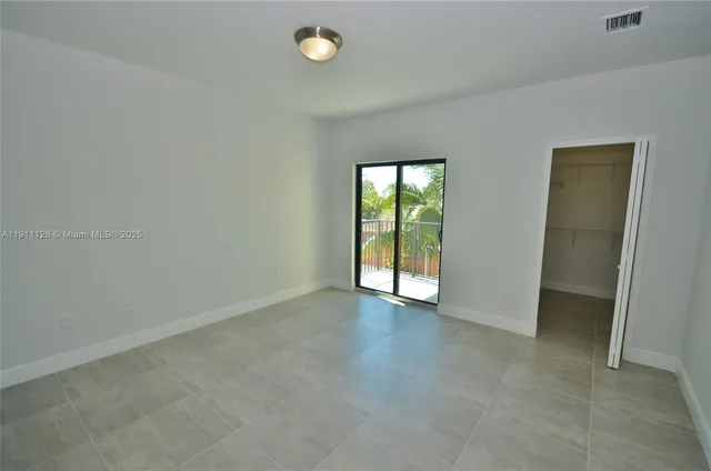 an empty room with sliding door and windows