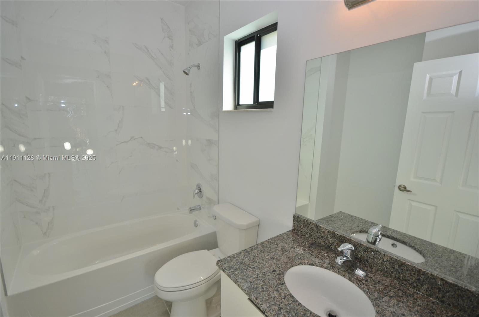 4374 East 10th Avenue, Unit 4374 Hialeah, FL 33013 - Photo 27 of 29 a bathroom with a granite countertop sink toilet a mirror and shower