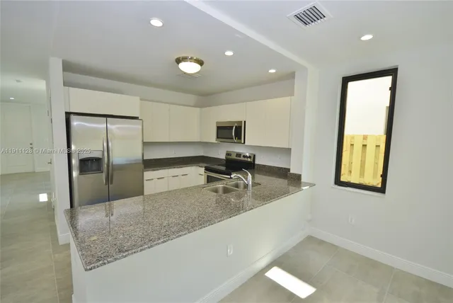a view of a kitchen with a sink and natural light