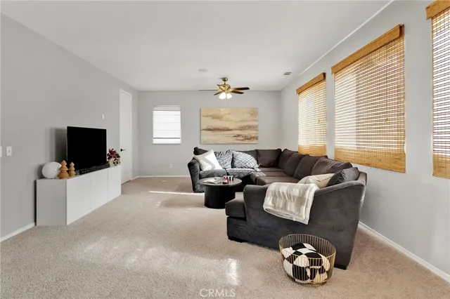 a living room with furniture a flat screen tv and a large window