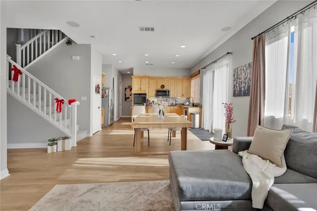 a living room with furniture and entryway with wooden floor