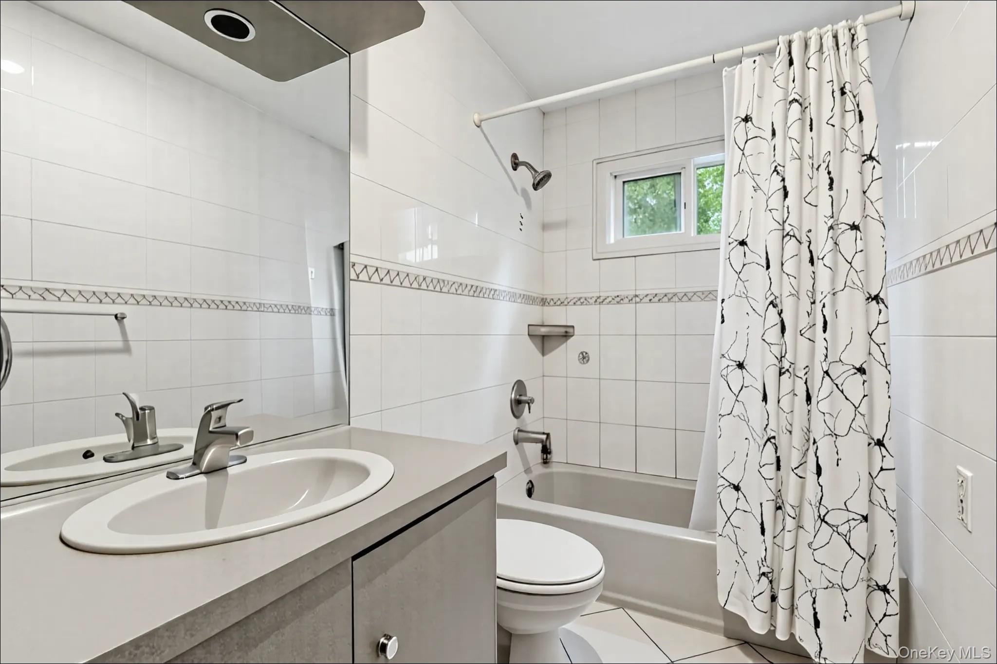 370 Blue Point Road Farmingville, NY 11738 - Photo 11 of 19 Bathroom featuring shower / tub combo with curtain, vanity, tile walls, and light tile patterned flooring