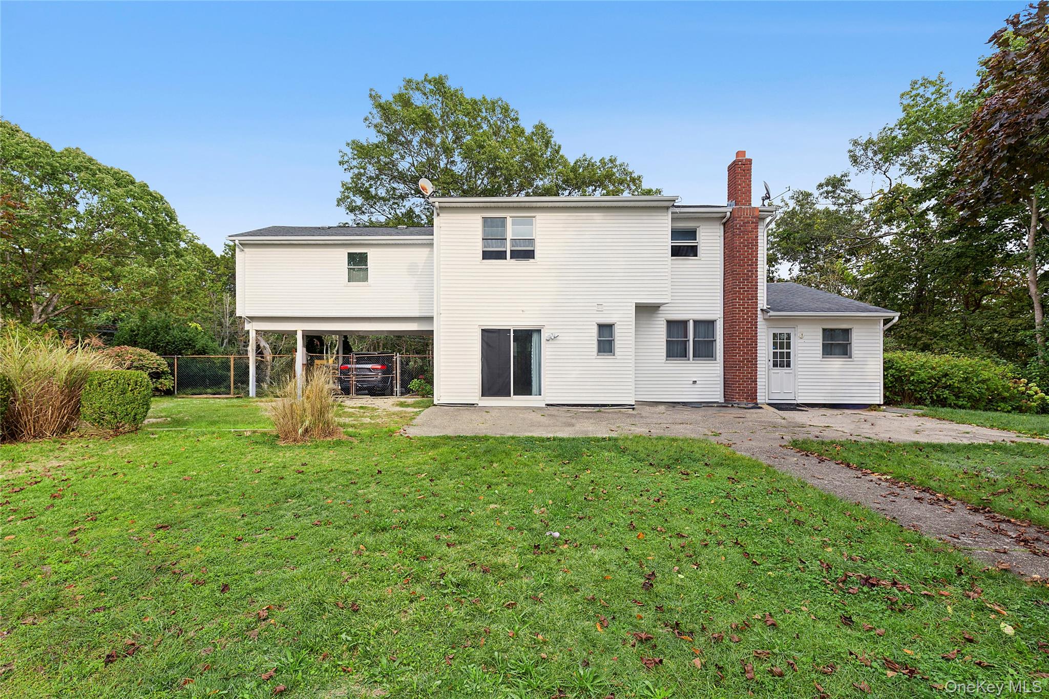 370 Blue Point Road Farmingville, NY 11738 - Photo 19 of 19 Rear view of house featuring a chimney and a patio