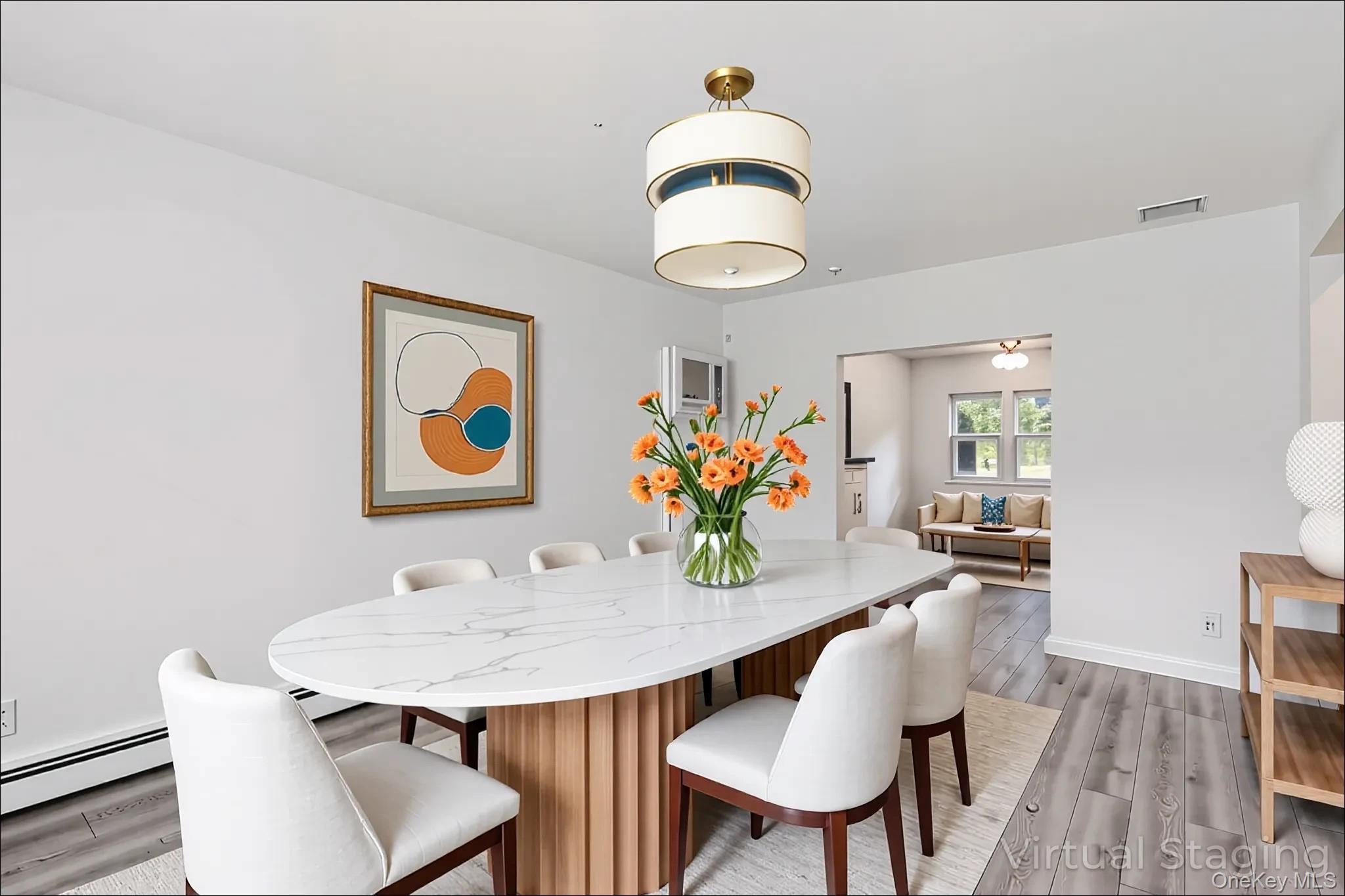 370 Blue Point Road Farmingville, NY 11738 - Photo 4 of 19 Dining area featuring light wood-type flooring and baseboard heating
