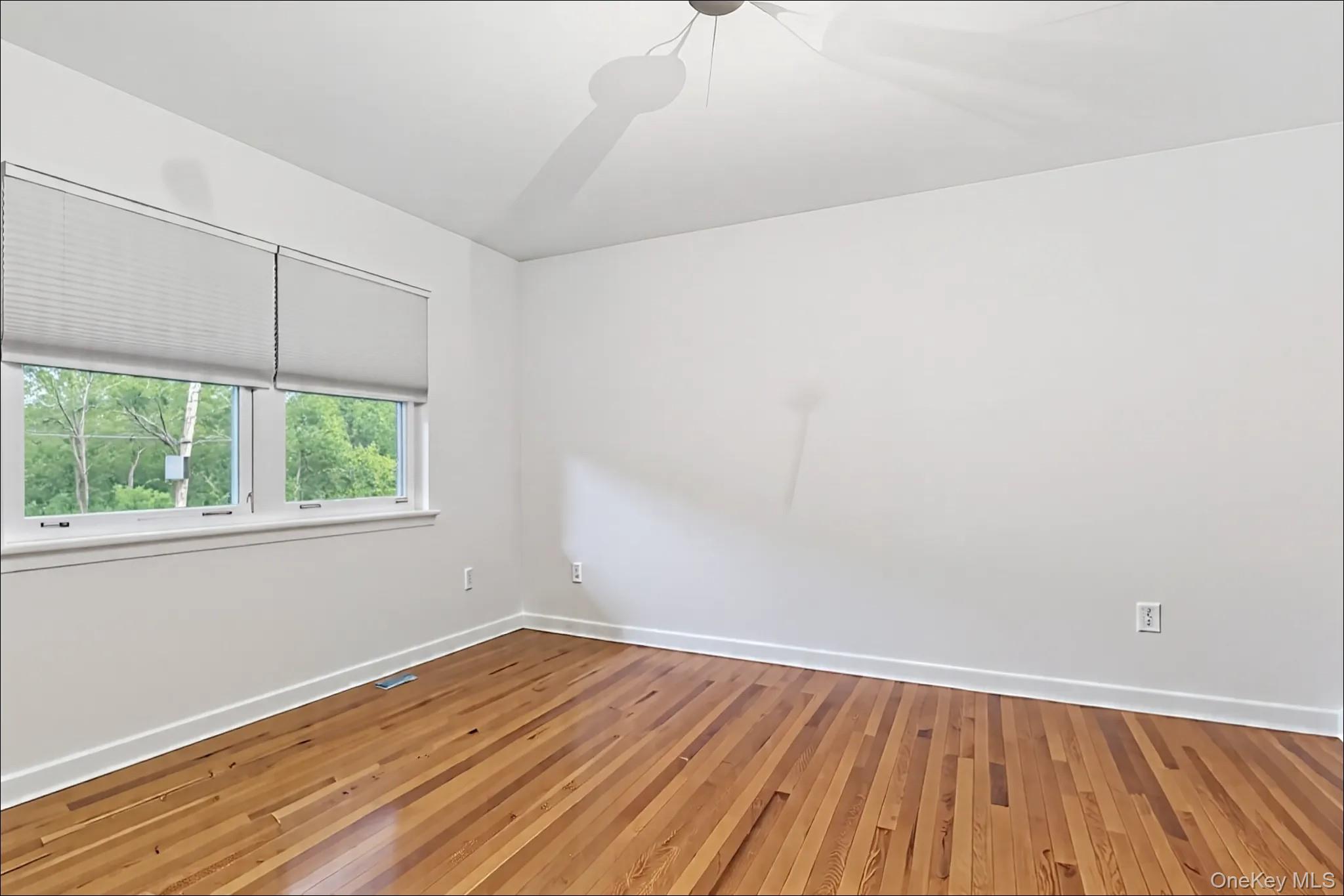 370 Blue Point Road Farmingville, NY 11738 - Photo 8 of 19 Spare room with hardwood / wood-style flooring and ceiling fan