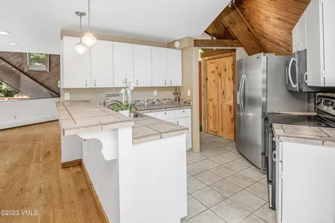 a kitchen with a refrigerator sink stove and cabinets