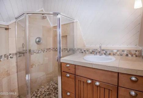 a bathroom with a granite countertop sink a shower and a mirror
