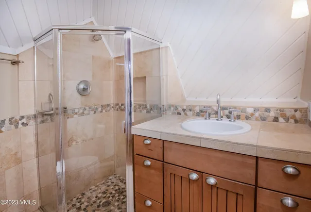 a bathroom with a granite countertop sink a shower and a mirror
