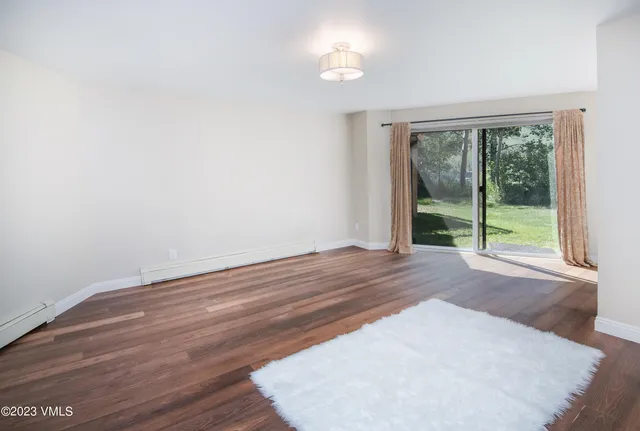 a view of a room with wooden floor and a window