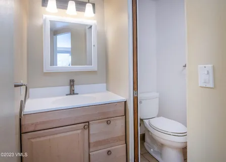 a bathroom with a toilet a sink and mirror