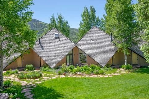 a house with green field in front of it