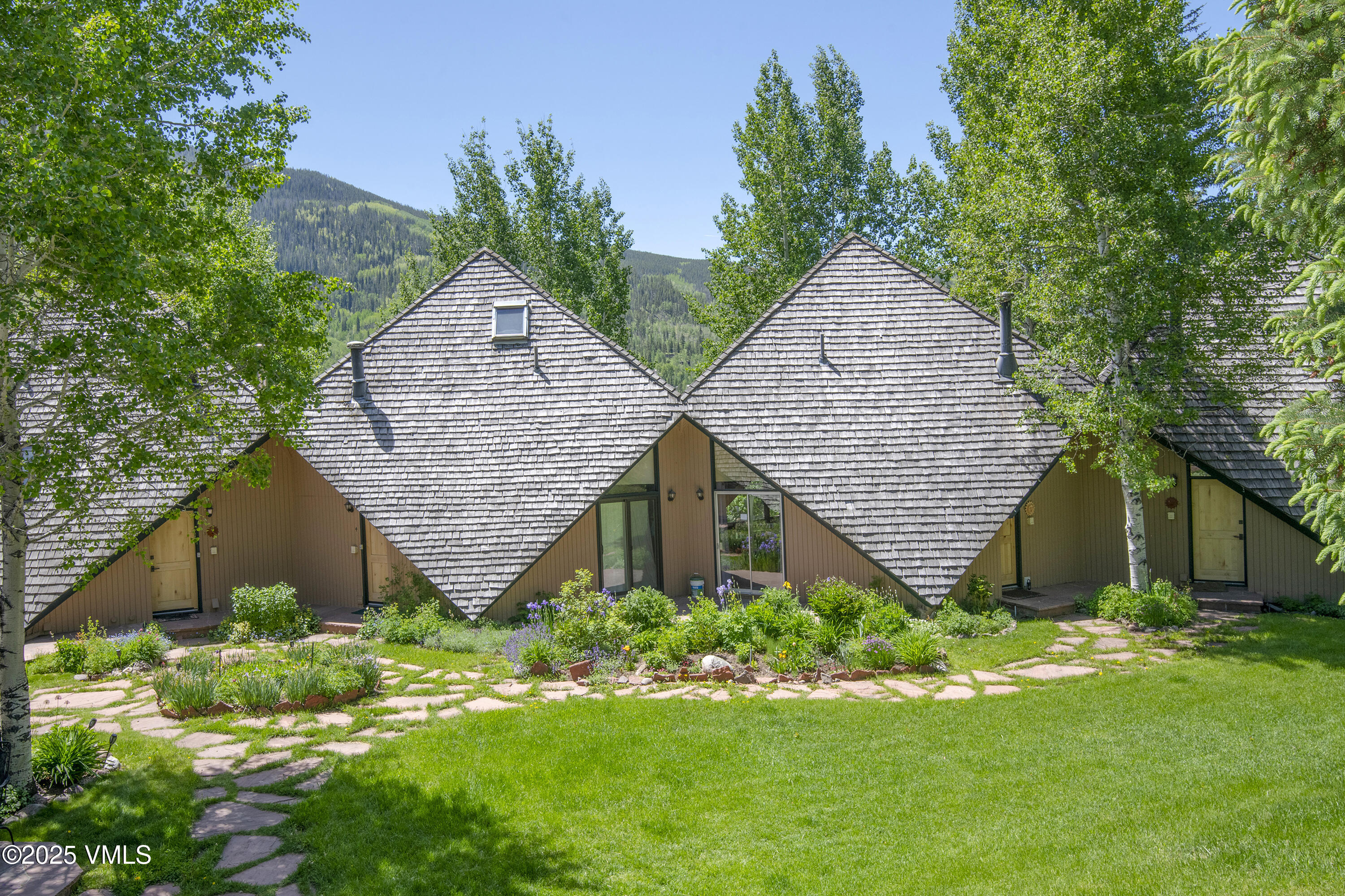 1400 Lions Ridge Loop, Unit A5 Vail, CO 81657 - Photo 29 of 32 a house with green field in front of it