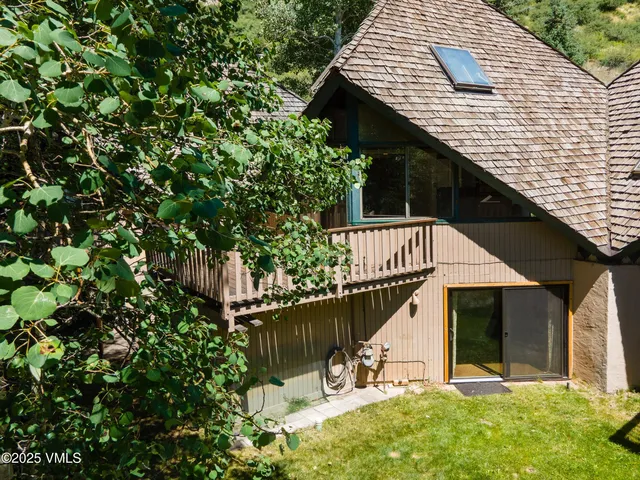 a roof deck with table and chairs under an umbrella