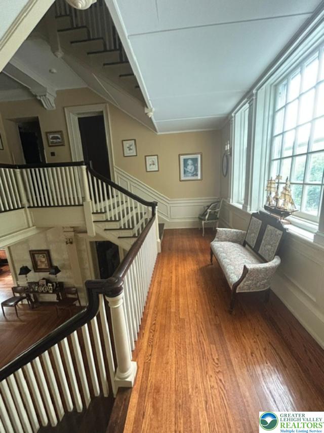 1170 Mosser Road Breinigsville, PA 18031 - Photo 18 of 19 Rich hardwood flooring leads to a grand staircase, showcasing traditional elegance and abundant natural light.