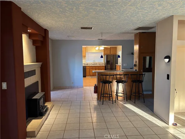 a view of an empty room with window and a kitchen