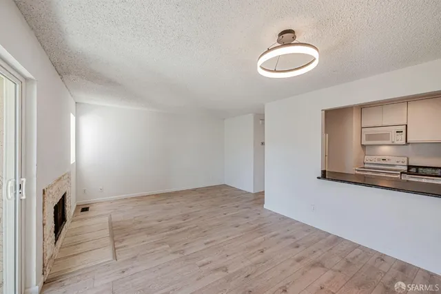 a view of a kitchen with a sink dishwasher and a fireplace