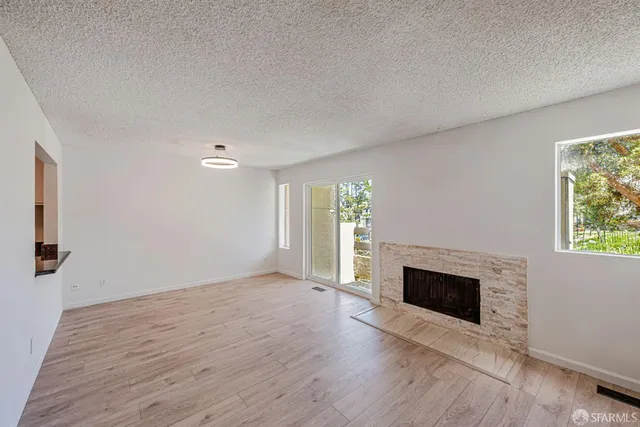 wooden floor fireplace and natural light in room