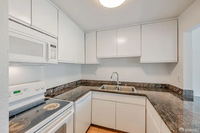a kitchen with stainless steel appliances granite countertop a sink stove and cabinets