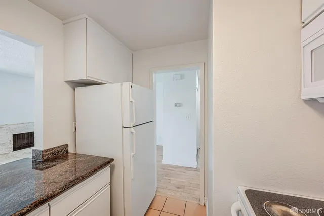 a kitchen with granite countertop a refrigerator and a sink
