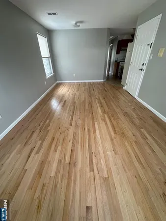 a view of empty room with wooden floor