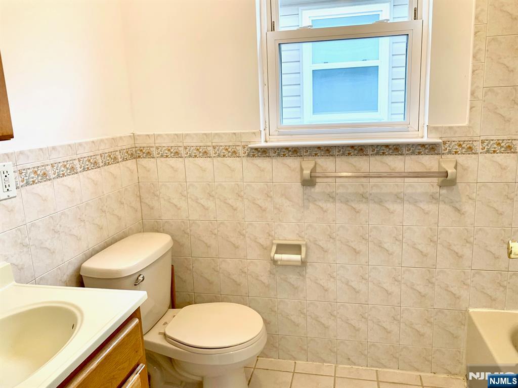 717 Jersey Street, Unit 2 Harrison, NJ 07029 - Photo 8 of 12 a bathroom with a toilet sink and mirror