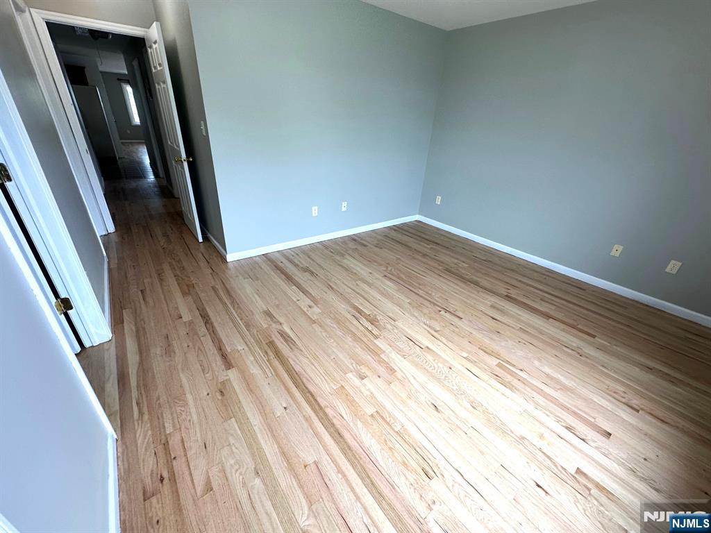 717 Jersey Street, Unit 2 Harrison, NJ 07029 - Photo 10 of 12 en empty room with wooden floor and stairs