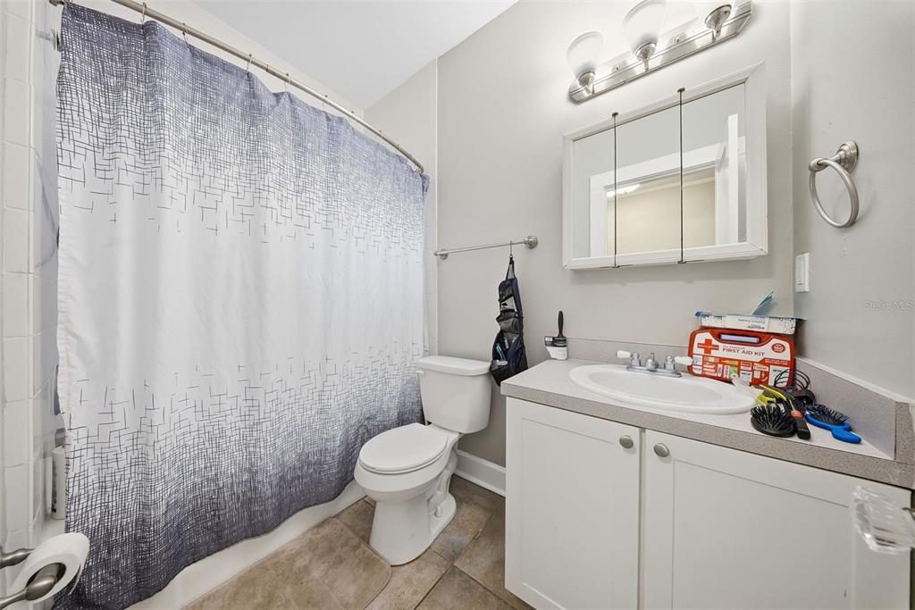 8334 Diagonal Road North St. Petersburg, FL 33702 - Photo 39 of 57 a bathroom with a sink a toilet and shower curtain