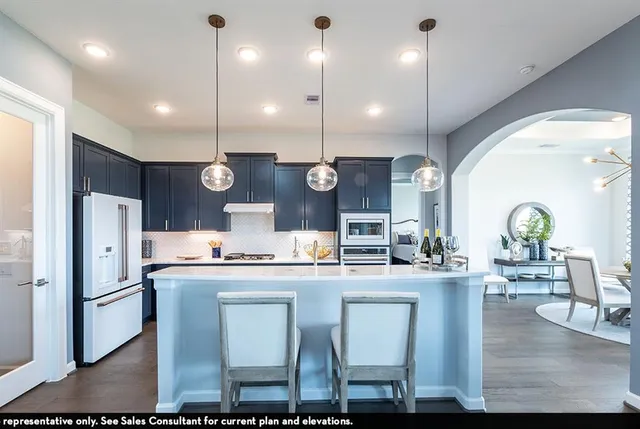 a kitchen with kitchen island granite countertop a sink a center island stainless steel appliances and cabinets