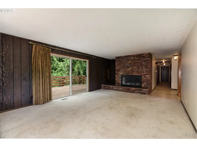 a view of an empty room with furniture and a fireplace