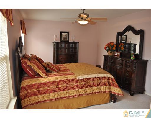 151 Skipton Place Somerset, NJ 08873 - Photo 9 of 10 a bedroom with a bed and a chandelier