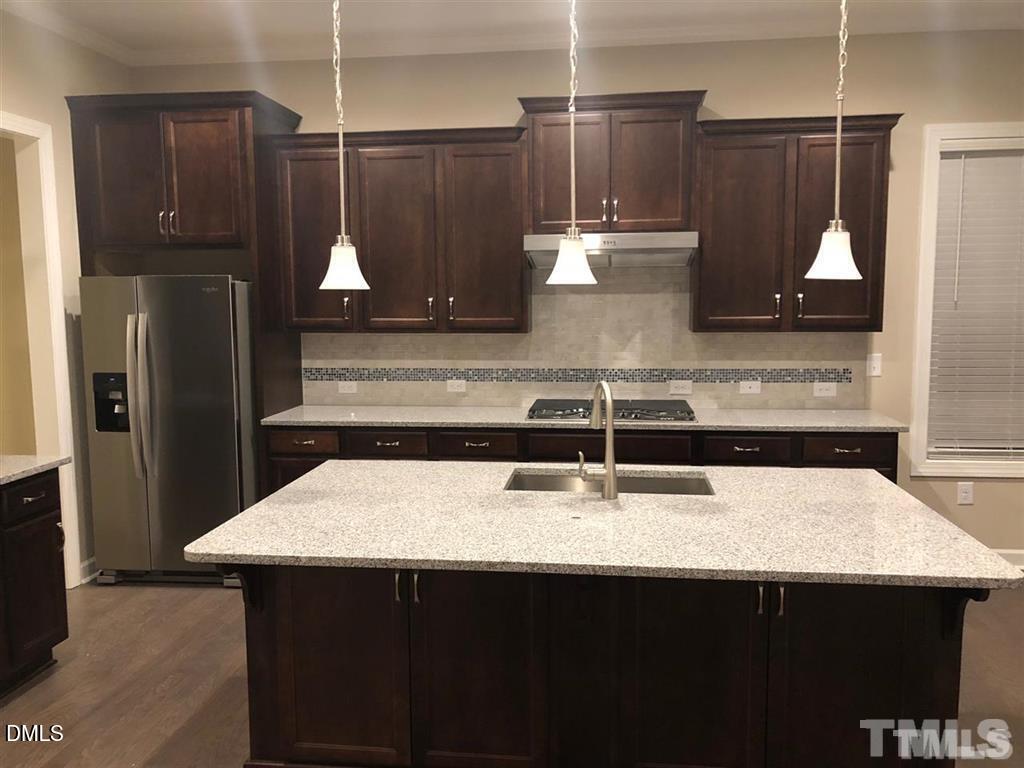 1600 Silo Ridge Drive Wake Forest, NC 27587 - Photo 2 of 16 a kitchen with a sink a refrigerator and wooden cabinets