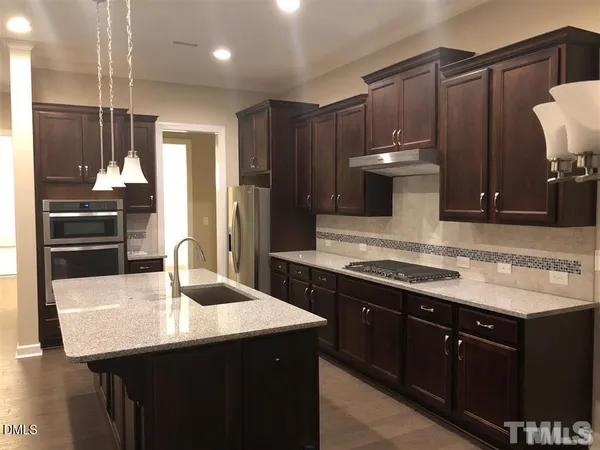 a kitchen with kitchen island a sink stainless steel appliances and cabinets