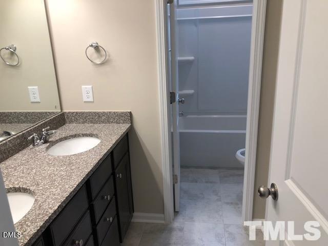 1600 Silo Ridge Drive Wake Forest, NC 27587 - Photo 9 of 16 a bathroom with a granite countertop sink and a mirror