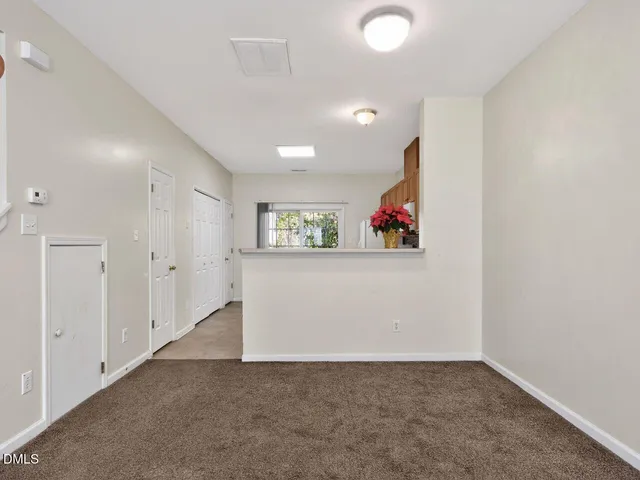 an empty room with a hallway and stairs