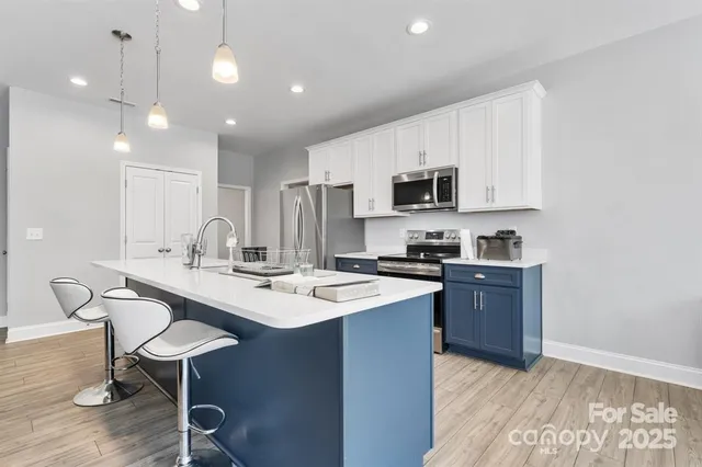 a kitchen with a sink a stove a refrigerator and chairs