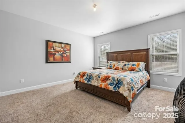 a bed sitting in a bedroom next to a window