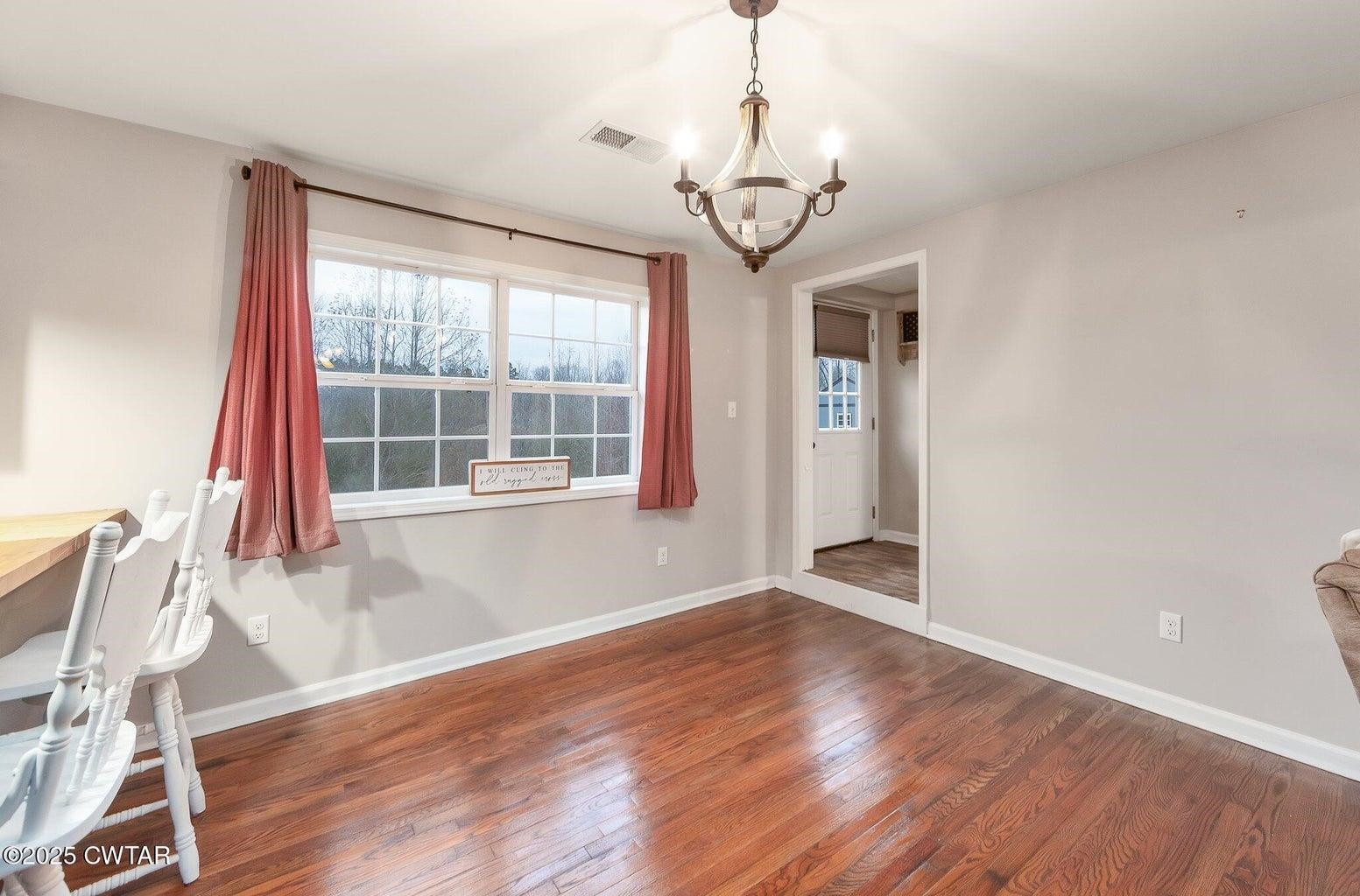 2510 Norton Road Middleton, TN 38052 - Photo 6 of 20 Unfurnished dining area with dark hardwood / wood-style flooring and a notable chandelier