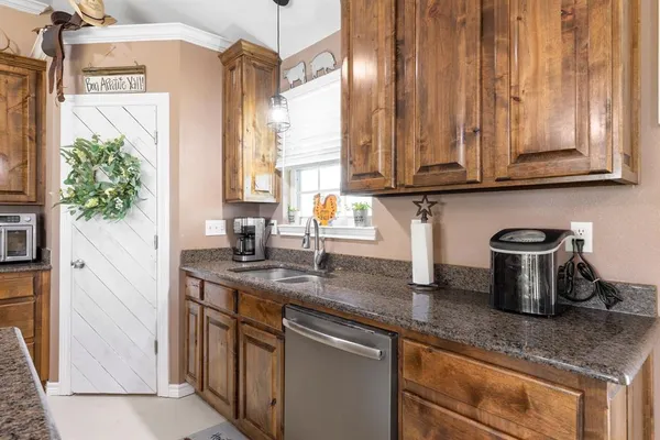 a kitchen with stainless steel appliances granite countertop a sink a microwave cabinets and a window