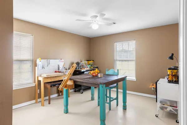 a view of a workspace with furniture and a window