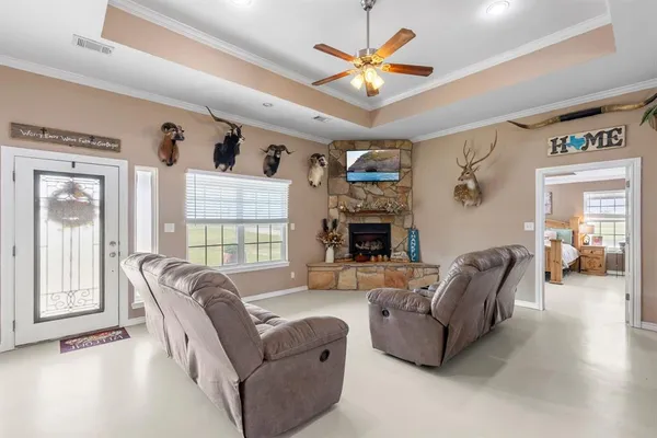 a living room with furniture a fireplace and a large window