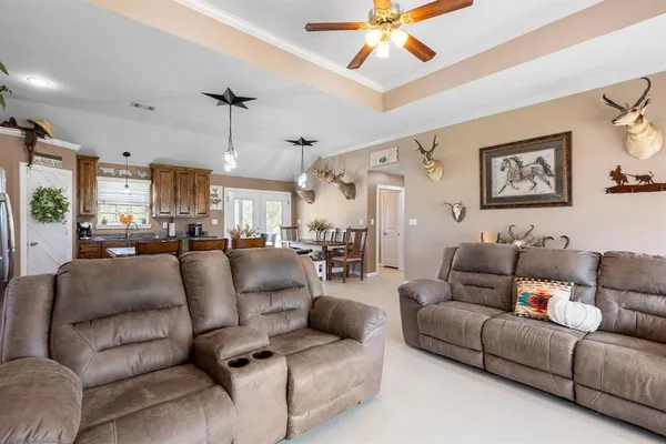 a living room with furniture and a view of kitchen